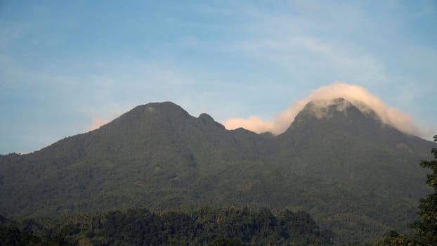 Mountains landscape, rainforest, jungle, blue sky, clouds and mist. Volcano on the island of Camiguin. Travel concept.
