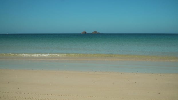 Wide sandy beach and palm trees by the sea. Nacpan, El Nido, Palawan, Philippines. Summer and travel vacation concept