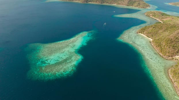aerial view tropical islands with blue lagoon, coral reef and sandy beach. Palawan, Philippines. Islands of the Malayan archipelago with turquoise lagoons.