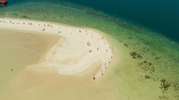 Luli island and sandy beach with tourists, sand bar surrounded by coral reef and blue sea in the honda bay, aerial drone. Tropical island and coral reef. Summer and travel vacation concept, Philippines, Palawan
