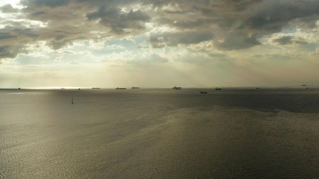 Colorful bright clouds during sunset over Manila bay with ships, aerial view. Sunset over ocean. Seascape, Summer and travel vacation concept.