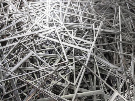 full frame abstract industrial background of stamping leftovers pile, close-up with selective focus.