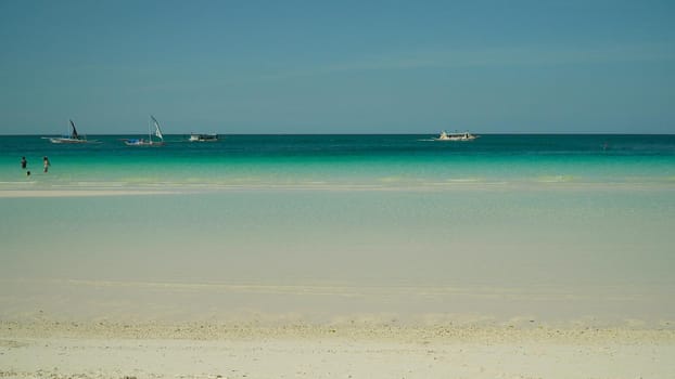 Tropical beach with boats and yachts on a background of sky. Summer and travel vacation concept.