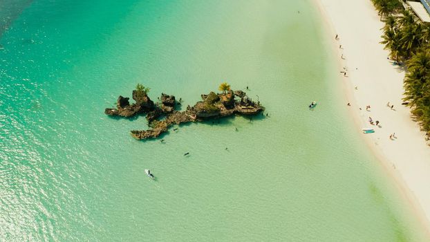 Topical white beach and Willy's rock with tourists and hotels on Boracay Island. Summer and travel vacation concept.