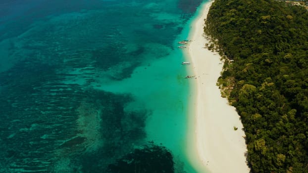 Travel concept: sand beach with tourists and turquoise water on Boracay, Philippines, aerial drone. Seascape with Puka shell beach on tropical island. Summer and travel vacation concept.