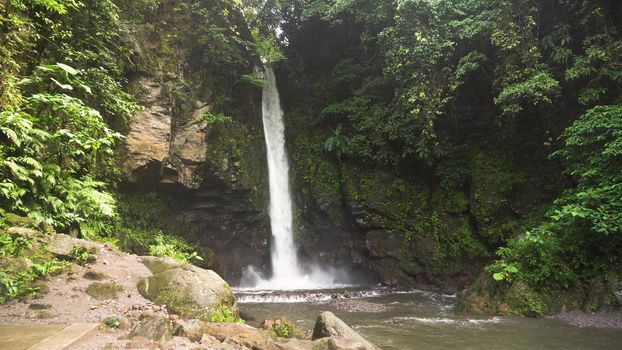 Beautiful waterfall in green forest in jungle. Waterfall in the mountains. Tropical rain forest with waterfall. Philippines, Camiguin. Travel concept.