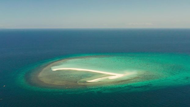 Beautiful beach on tropical island surrounded by coral reef, sandy bar with tourists, top view. Sandbar Atoll. Summer and travel vacation concept, Camiguin, Philippines.