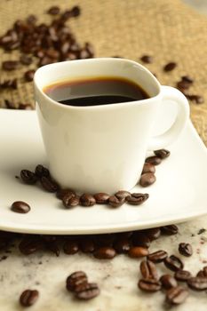 A single cup of espresso in an aromatic roasted coffee bean scene.