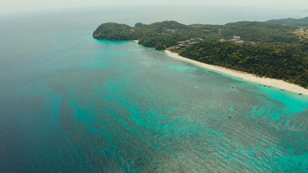 Sandy beach and turquoise water in the tropical resort of Boracay, Puka shell beach, Philippines aerial view. White beach with tourists. Summer and travel vacation concept.