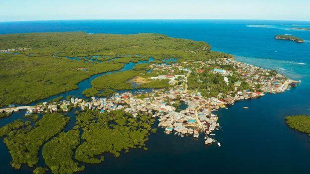 City in wetlands and mangroves on the ocean coastline aerial view. Siargao island, Philippines.