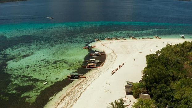 Small tropical island on an atoll with beautiful sandy beach surrounded by coral reef from above. Tropical island and coral reef. Summer and travel vacation concept, Camiguin, Philippines, Mindanao