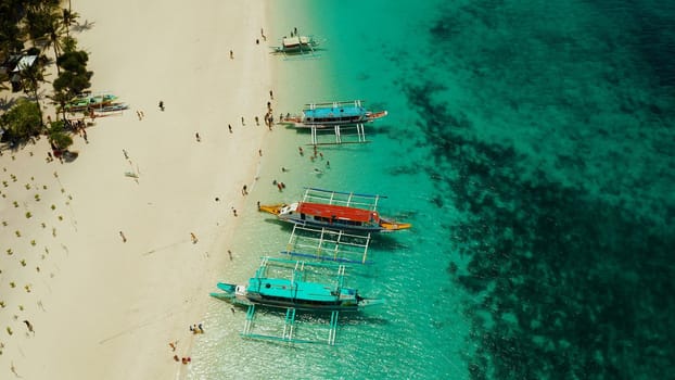 Tropical landscape: Sandy beach with palm trees and turquoise waters of the coral reef top view, Puka shell beach. Boracay, Philippines. Seascape with beach on tropical island. Summer and travel vacation concept.