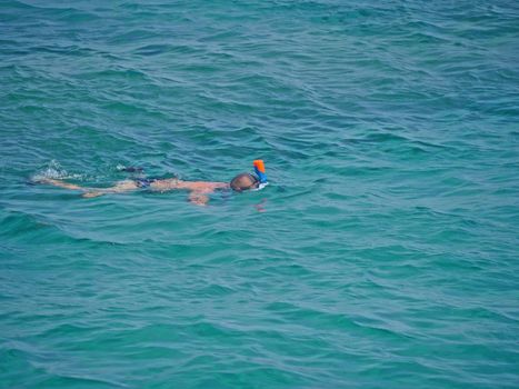 man in a mask dives under the water