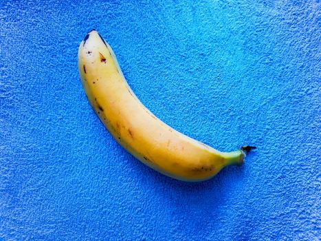 Yellow banana lie on blue towel