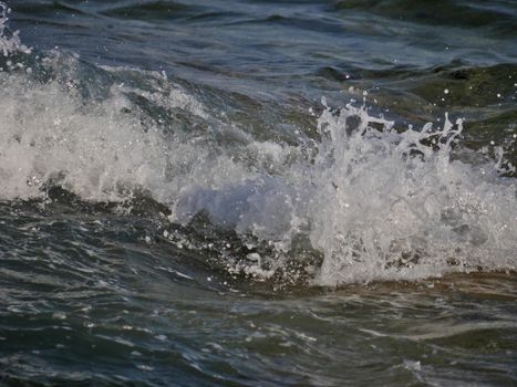 sea wave crashing against the rock cliff