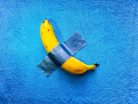 Yellow banana lie taped on blue towel