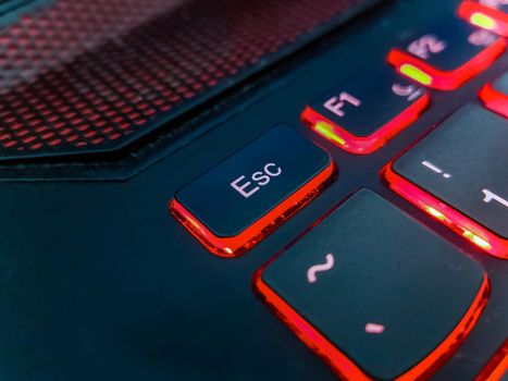 Keyboard of laptop highlighted by red lights