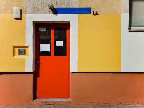 Red steel doors of block of flats with colorful walls