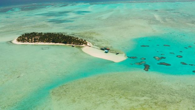 Tropical landscape: small island with beautiful beach, palm trees by turquoise water view from above. Onok Island, Balabac, Philippines. Summer and travel vacation concept