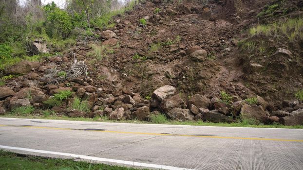 Landslides and rockfalls on the road in the mountains. Mud and rocks blocking the road.Destroyed rural road landslide damaged in powerful flood. Collapsed on the mountain. Philippines, Camiguin.
