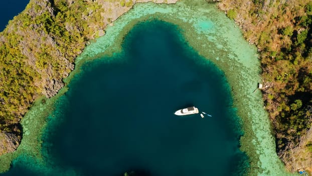 Aerial drone speed boat with tourists in beautiful lagoon. tropical landscape. blue lagoon surrounded by rocks on tropical island. Seascape, tropical landscape. Palawan, Philippines, Busuanga