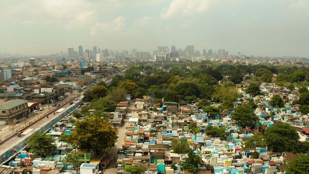 The city of Manila, the capital of the Philippines and Manila North Cemetery, top view. Modern buildings in the city center.