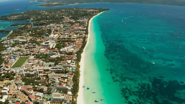 Travel concept: sandy tropical beach with hotels and tourists near the blue lagoon, aerial view, Boracay, Philippines. Seascape with beach on tropical island. Summer and travel vacation concept.