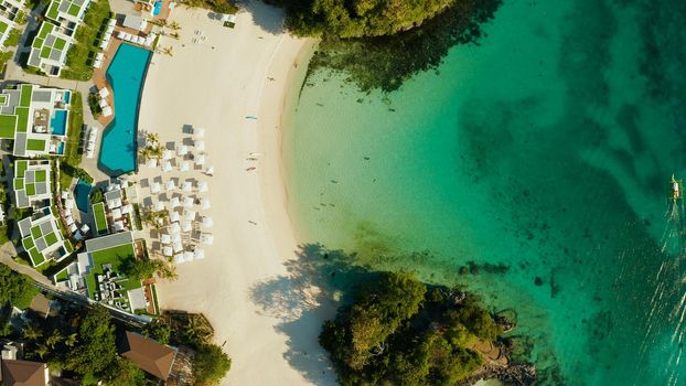 Cove with white beach in blue lagoon with turquoise waters, aerial view. Seascape with beach on tropical island. Summer and travel vacation concept.