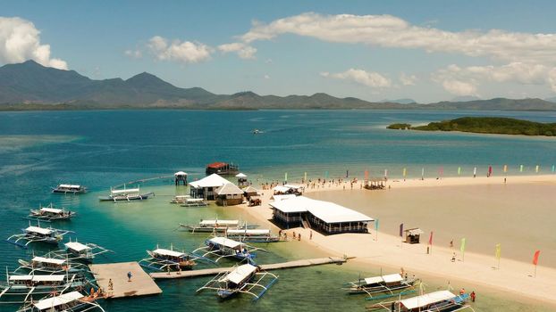 Beautiful beach on tropical island surrounded by coral reef, sandy bar with tourists. honda bay top view. Luli island. Summer and travel vacation concept, Philippines, Palawan