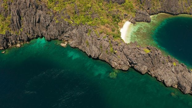 Aerial drone tropical landscape bay with beach and clear blue water surrounded by cliffs. El nido, Philippines, Palawan. Seascape with tropical rocky islands, ocean blue water. Summer and travel vacation concept
