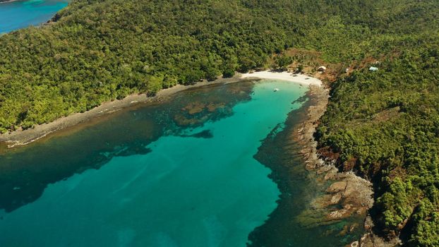 aerial view tropical sandy beach with coral reef and blue lagoon surrounded by rainforest. Palawan, Philippines. tropical landscape. Seascape island and clear blue water. Summer and travel vacation concept