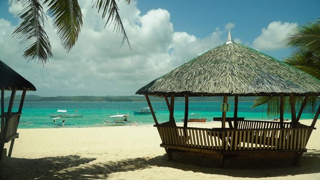 Bungalow on a tropical beach with palm trees and blue sea of Daco, Philippines. Summer and travel vacation concept