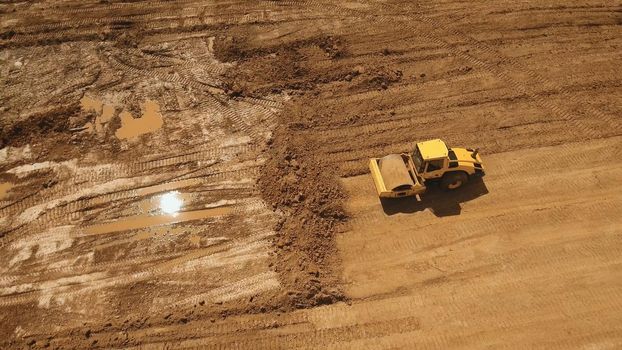 Construction of a new road in the forest area. Aerial view construction road place. Construction machinery for the construction of a road in the forest.