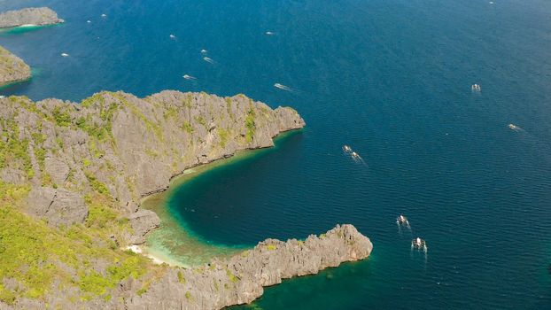 Cove with tourist boats and the tropical islands. Seascape with tropical rocky islands, ocean blue water. islands and mountains covered with tropical forest. El nido, Philippines, Palawan. Tropical Mountain Range