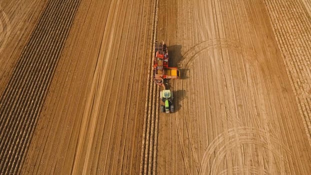 Farm machinery harvesting potatoes. Farmer field with a potato crop.