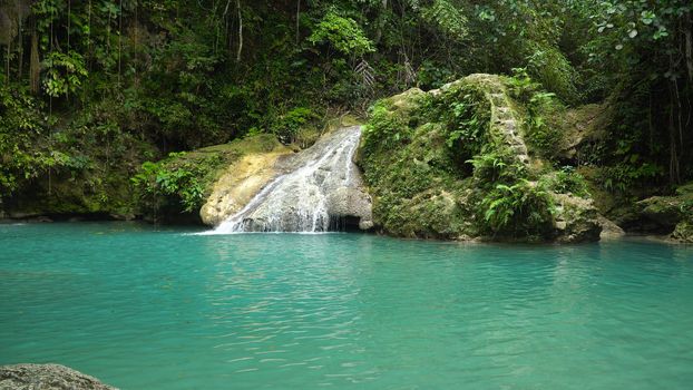 Beautiful waterfall in green forest. Tropical Cambais Falls in mountain jungle, Philippines, Cebu. Waterfall in the tropical forest.