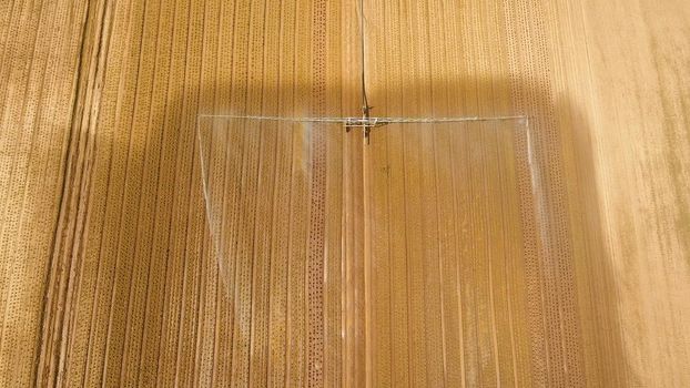 Aerial view: Crop Irrigation using the center pivot sprinkler system. An irrigation pivot watering salad, lettuce field. Irrigation system watering farm field.
