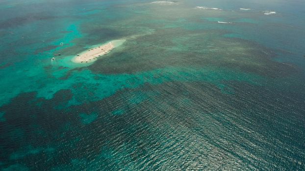 Sandy white island with beach and sandy bar in the turquoise atoll water, aerial drone. Tropical island and coral reef. Naked Island, Siargao.
