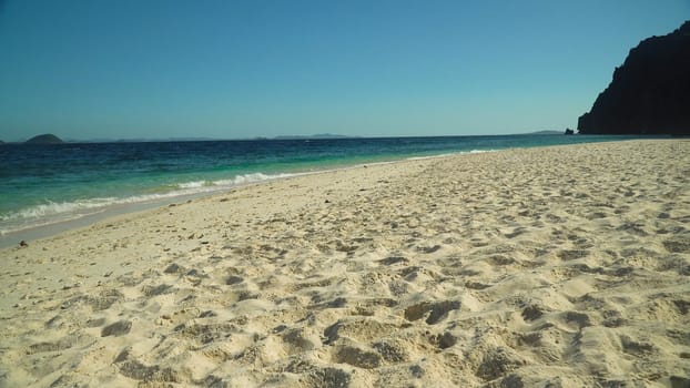 Tropical sandy beach and blue sea with waves. Malajon Island, Philippines, Palawan. Summer and travel vacation concept. beach and blue clear sea water