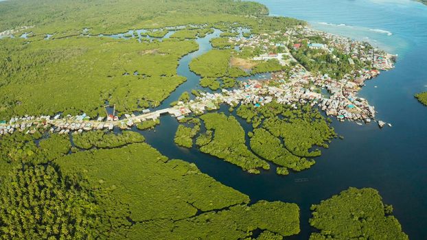 City in wetlands and mangroves on the ocean coastline aerial view. Siargao island, Philippines.