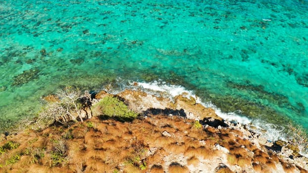 aerial view water surface with waves and coast tropical island. Lagoon with turquoise water. top view blue water