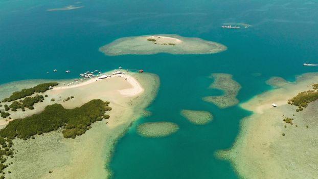 Beautiful beach on tropical island surrounded by coral reef, sandy bar with tourists. honda bay top view. Luli island. Summer and travel vacation concept, Philippines, Palawan
