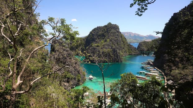 Tropical lagoon with azure water, beach by the Kayangan Lake, Philippines. View Coron island, with cove, bay at Kayangan lake. Lagoon with sailing boats. Philippines. Travel concept