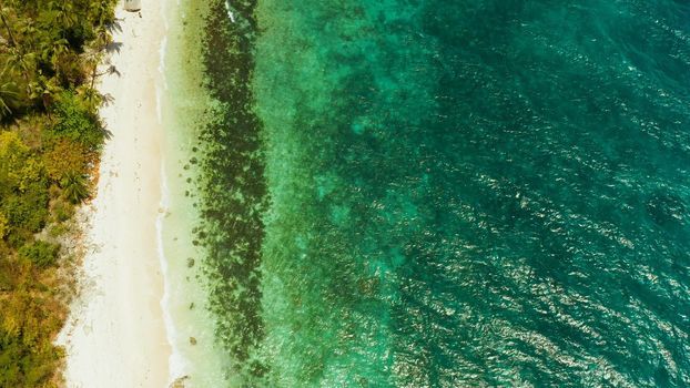 White sandy beach and azure water of the lagoon,copy space for text, top view. Ocean with waves and tropical beach. Summer and travel vacation concept