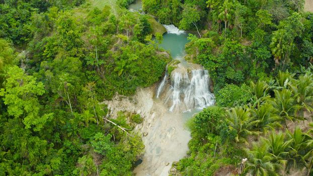 Aerial top view jungle Waterfall in a tropical forest surrounded by green vegetation. Mantayupan Falls in mountain jungle. Philippines, Cebu.