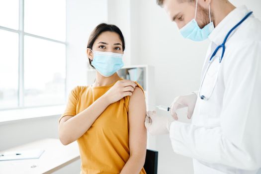 professional doctor holds a syringe in his hand and a female patient. High quality photo