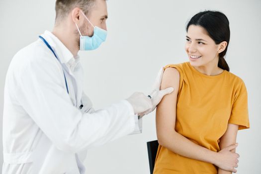 doctor tapes an injection on the shoulder of a happy patient with adhesive tape. High quality photo