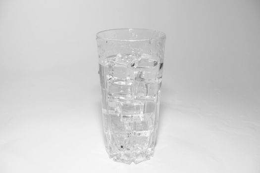 water splashes in a glass with ice on a white background. High quality photo