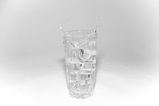 water splashes in a glass with ice on a white background. High quality photo