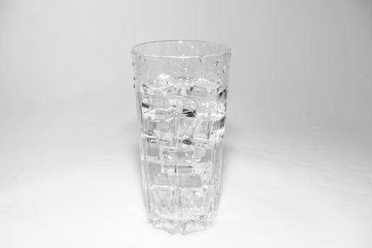water splashes in a glass with ice on a white background. High quality photo